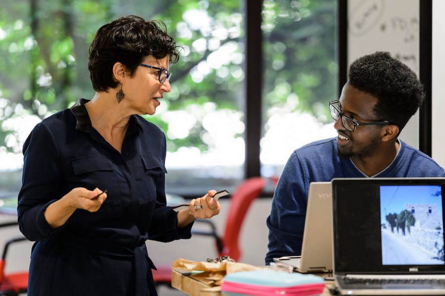 Lesley Sager, faculty associate in design studies, talks with undergraduate student Fuad Ahmed while he works at a laptop.